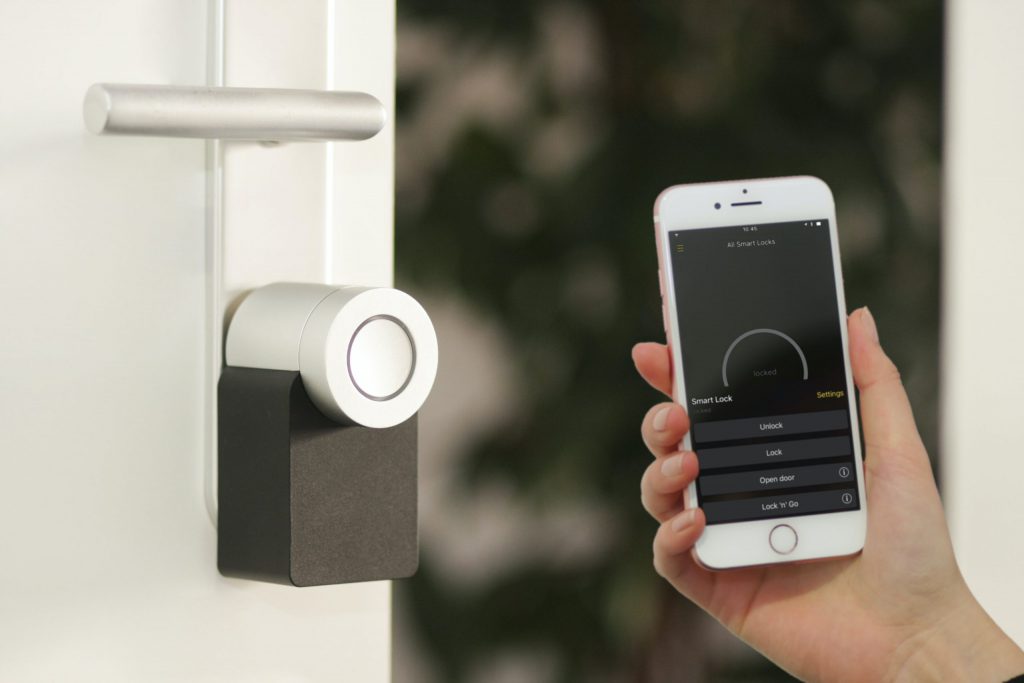 Smart phone next to a smart home thermostat