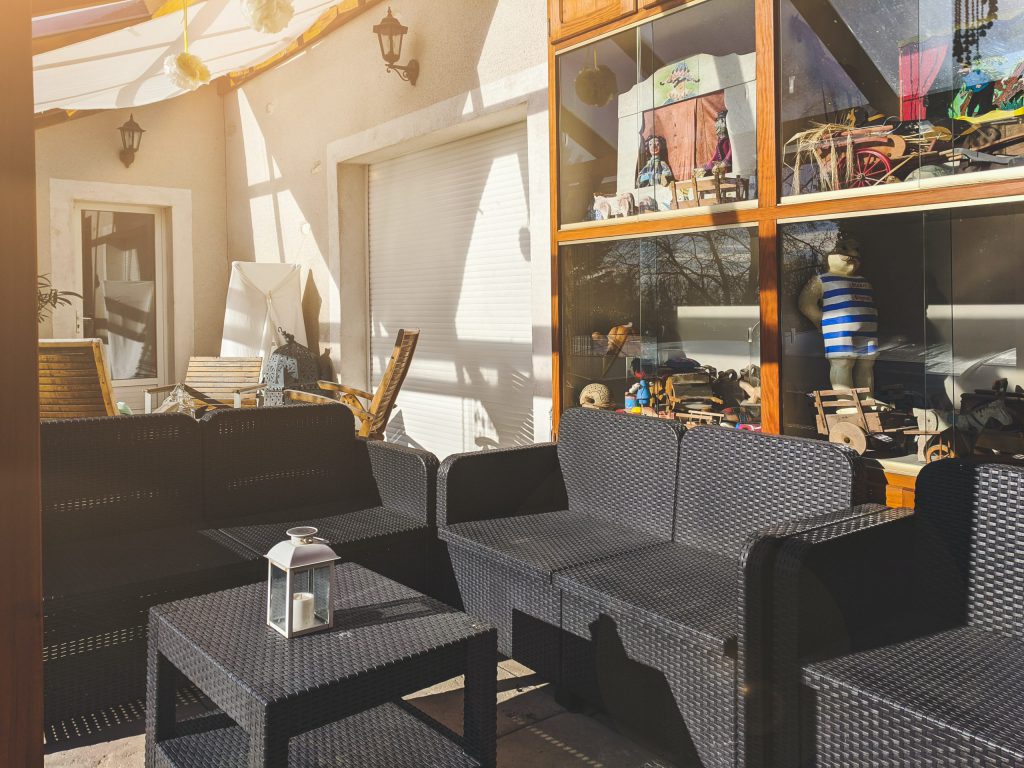 outdoor room with dark couches and shelves in the background