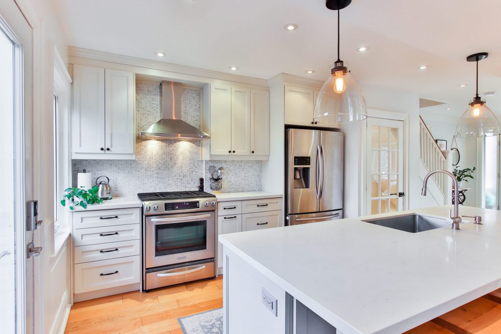 modern kitchen with white countertops and silver appliances